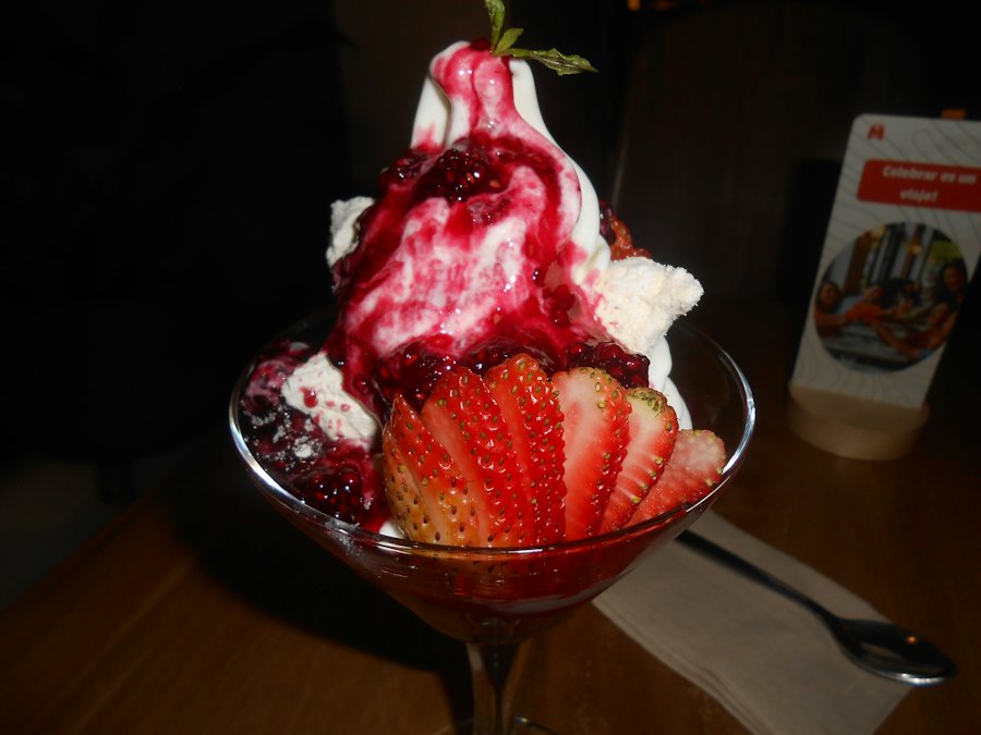 Coupe glacée avec coulis de fruits rouges (photo d'illustration)